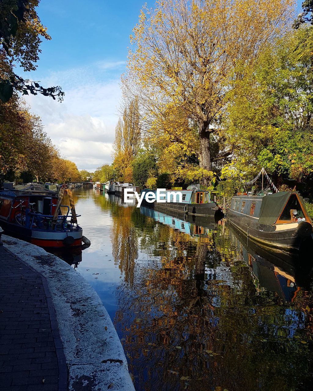 BOATS MOORED ON RIVER AGAINST SKY