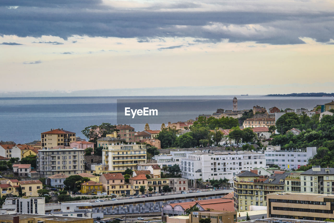 HIGH ANGLE VIEW OF TOWNSCAPE BY SEA