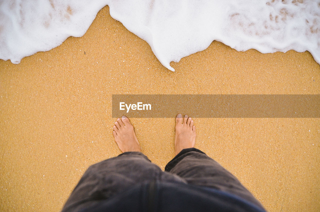 Low section of person standing on beach