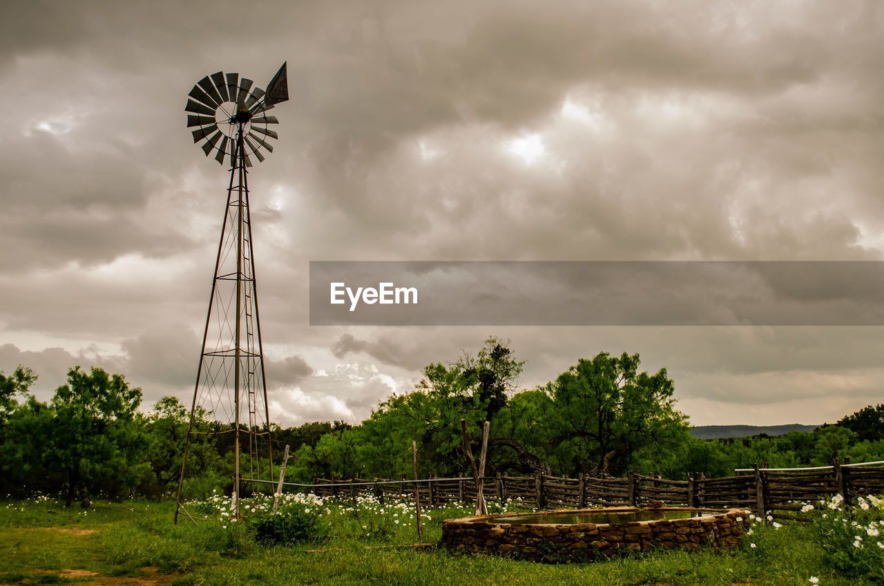 Old windmill water trough under dramatic sky