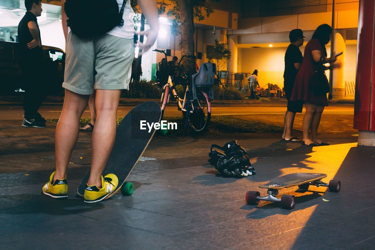 LOW SECTION OF PEOPLE ON FOOTPATH IN CITY AT NIGHT