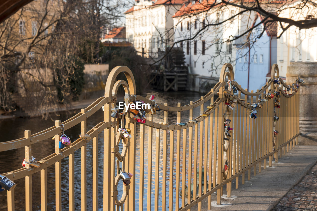 Love locks hanging on a metal fence by the river