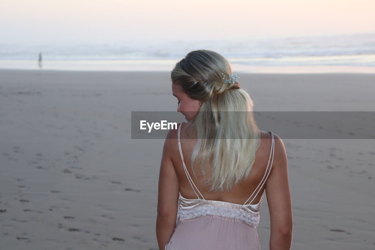 WOMAN STANDING AT BEACH