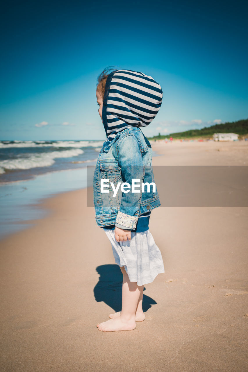 Side view of girl standing at beach