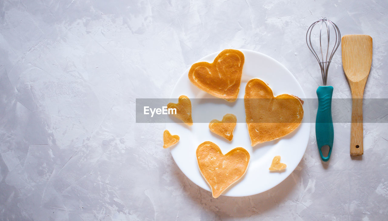 Creative breakfast for valentine's day. heart shaped pancakes with strawberries on a plate