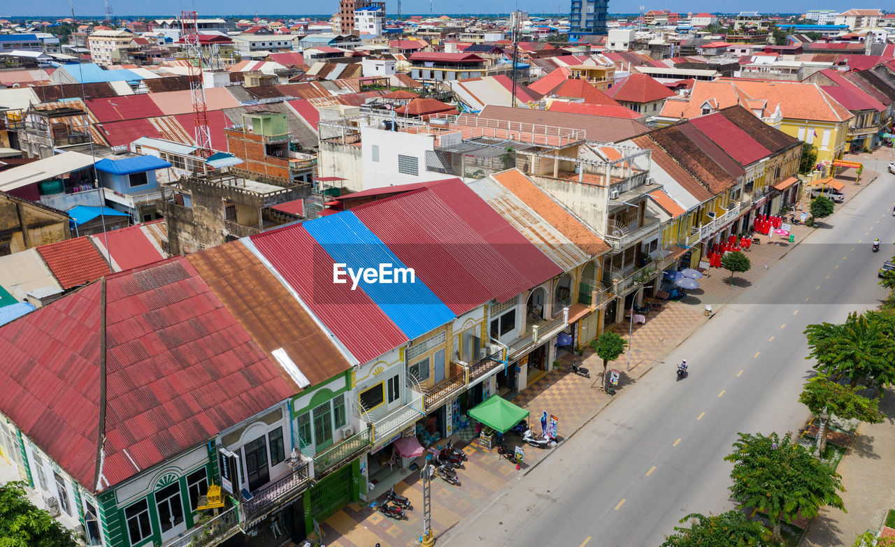 HIGH ANGLE VIEW OF CARS ON ROAD AGAINST BUILDINGS