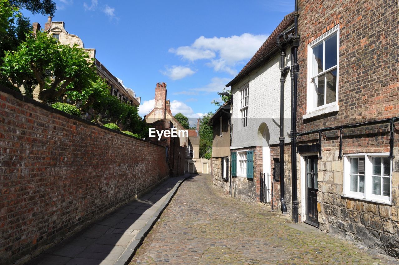 Alley amidst buildings against sky