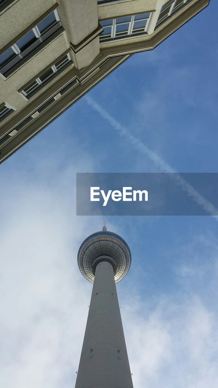 Low angle view of fernsehturm and building against sky
