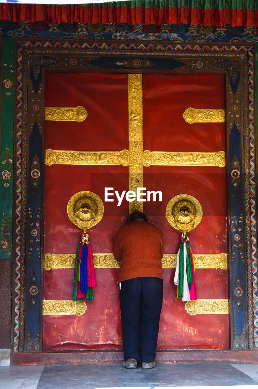 REAR VIEW OF PEOPLE STANDING IN FRONT OF TEMPLE