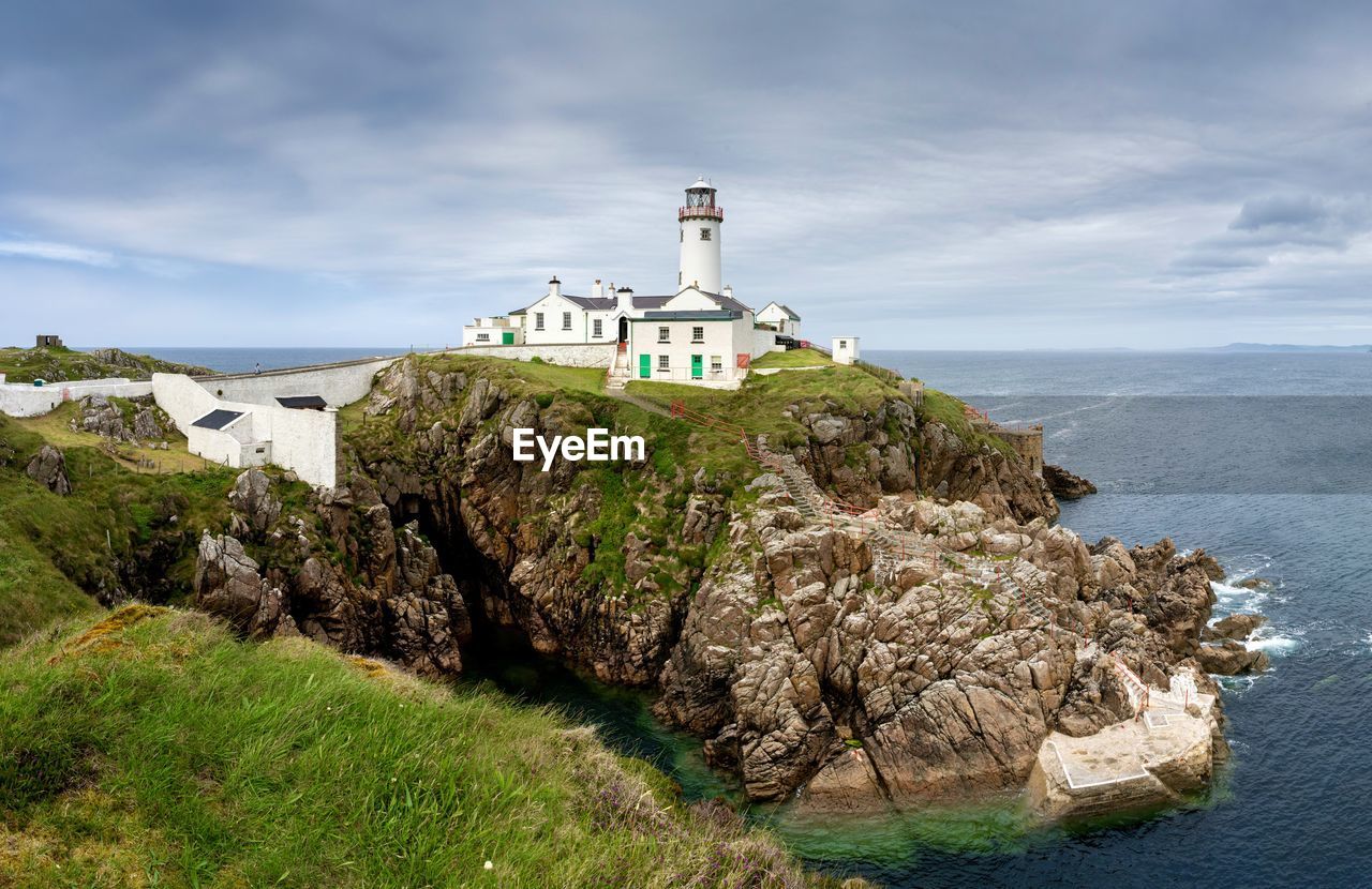 Lighthouse in ireland with sea an sky backdrop