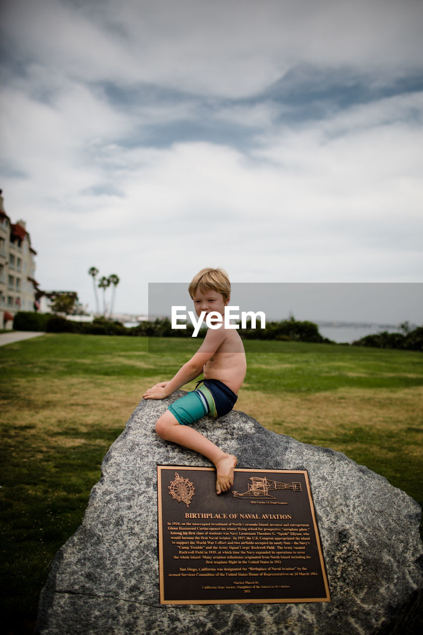 Shirtless six year old boy sitting on rock in coronado