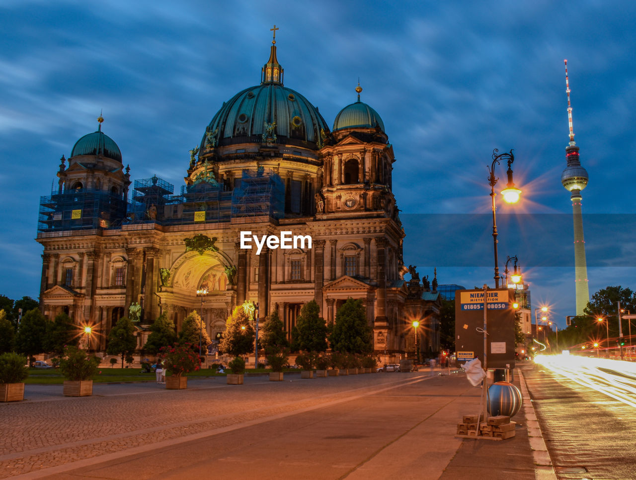 VIEW OF ILLUMINATED CATHEDRAL AGAINST BUILDINGS