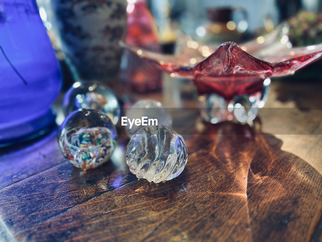 table, close-up, wood, no people, indoors, selective focus, still life, jewelry, blue, macro photography, wealth, shiny, glass, focus on foreground, luxury, diamond