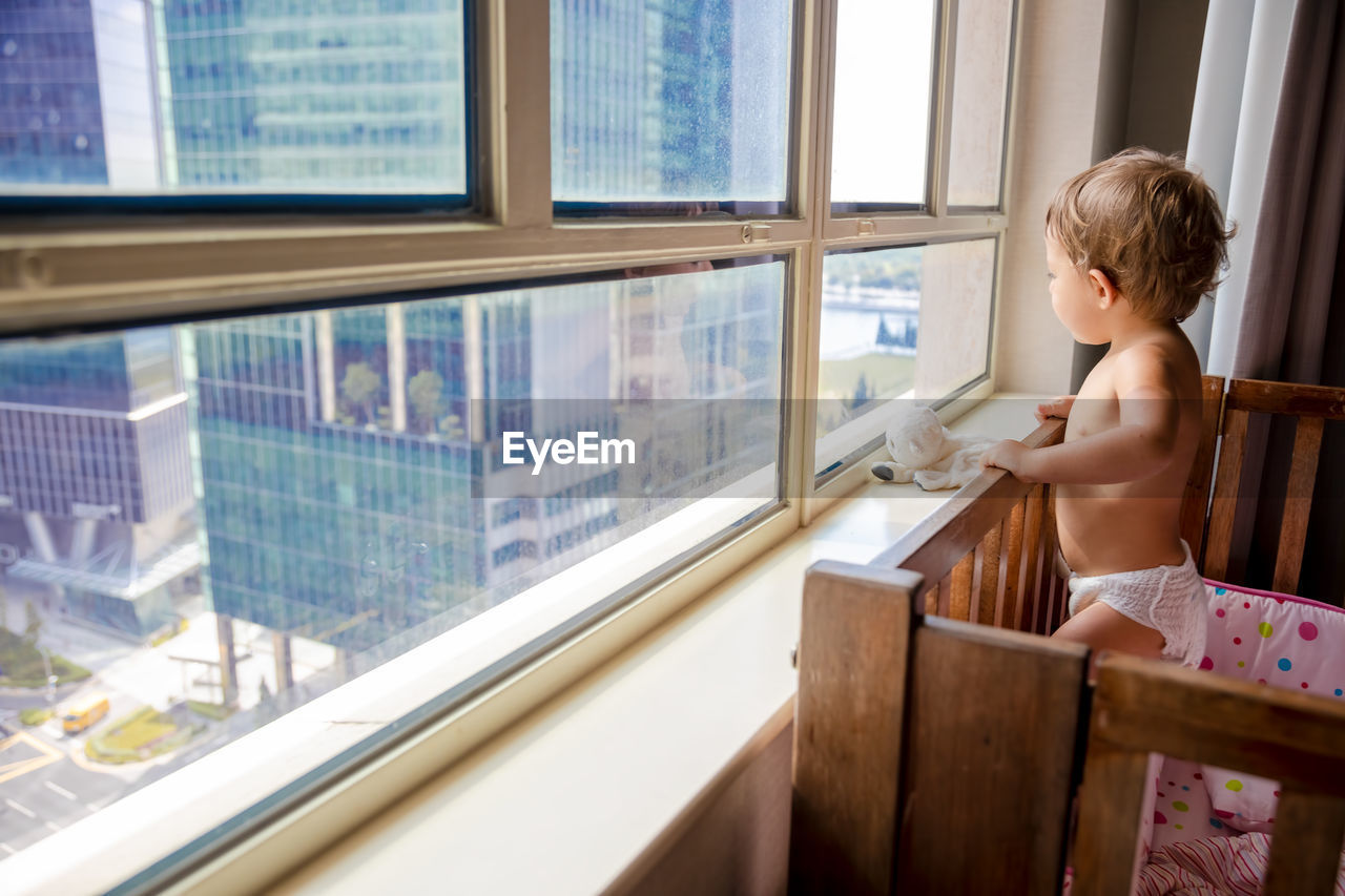 Boy looking through window