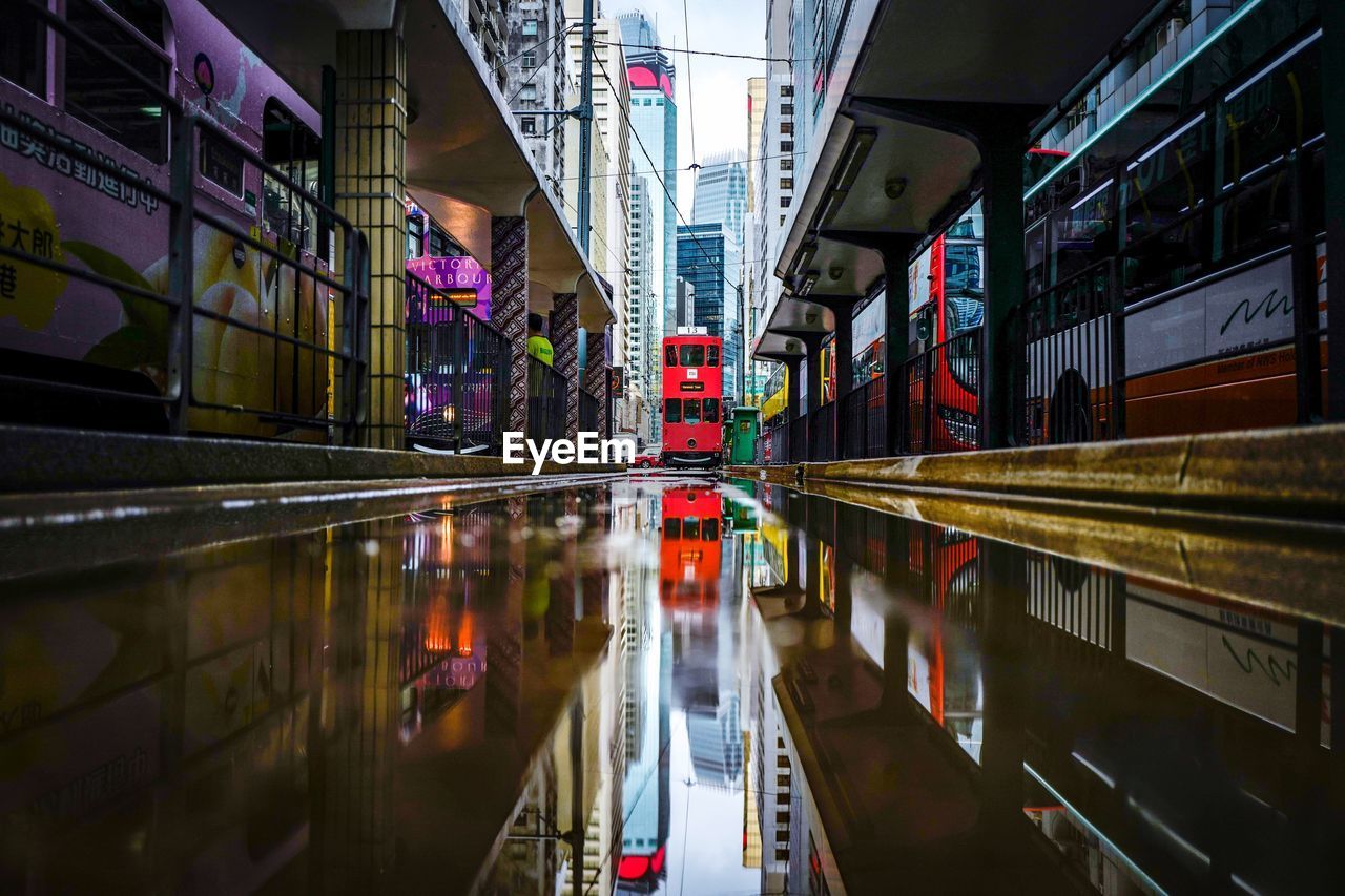 Reflection of illuminated buildings in puddle on street