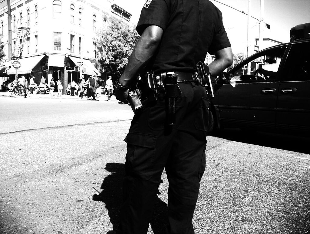 Midsection of police officer with walkie-talkie on equipment belt