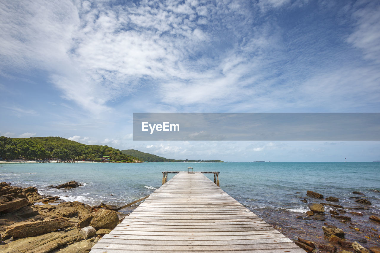 Wide angle shot of dock to the sea with bright blue sky and cloud in relax summer day