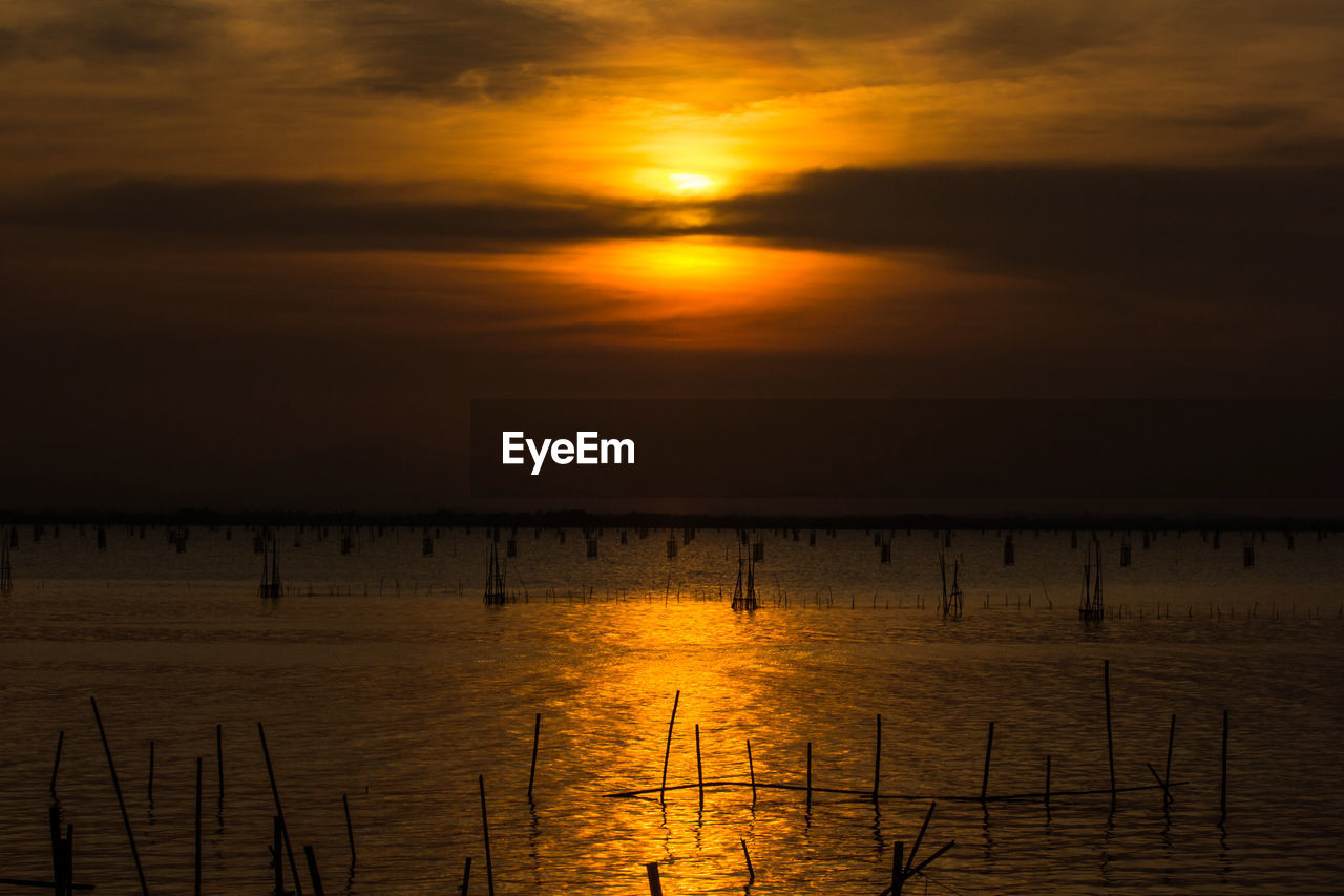 sky, water, sunset, beauty in nature, scenics - nature, tranquility, tranquil scene, sea, nature, cloud, orange color, reflection, sun, afterglow, idyllic, silhouette, evening, dawn, sunlight, no people, horizon, dramatic sky, non-urban scene, beach, outdoors, horizon over water, land, waterfront