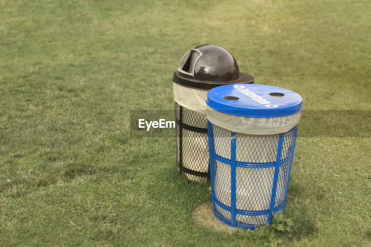 HIGH ANGLE VIEW OF GARBAGE CAN ON GRASS