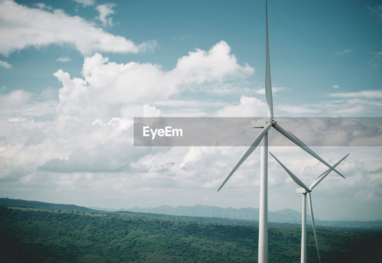 Windmill on landscape against sky