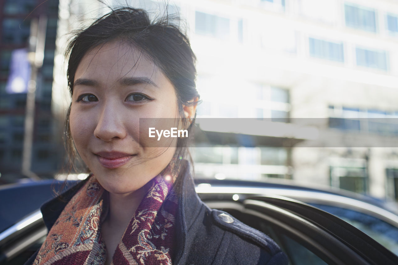 Young asian businesswoman looking in camera in urban environment