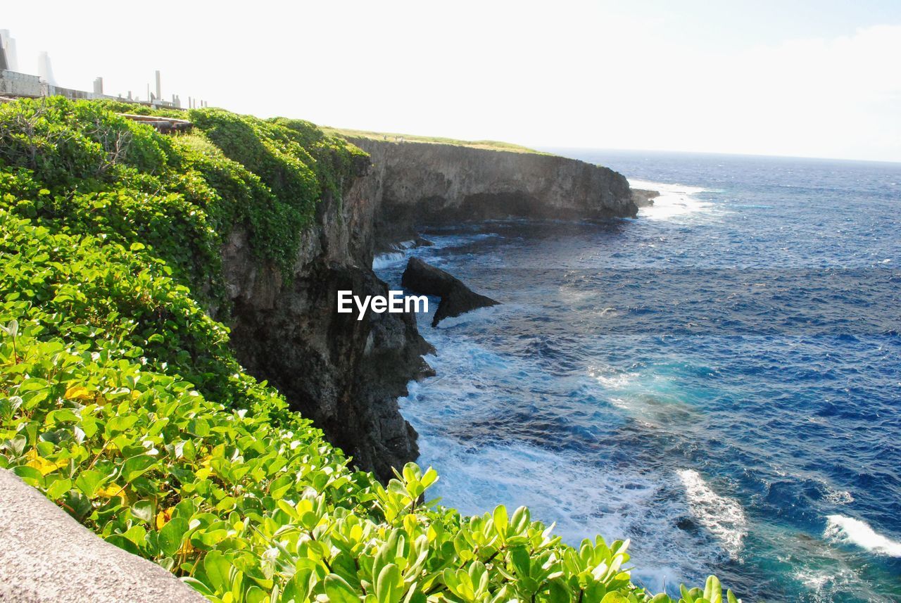 SCENIC VIEW OF ROCKY BEACH AGAINST SKY