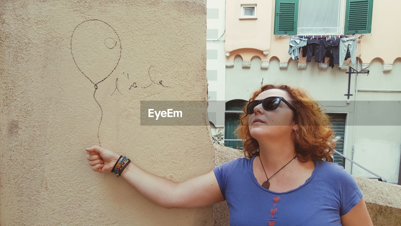 Optical illusion of woman holding balloon drawn on wall