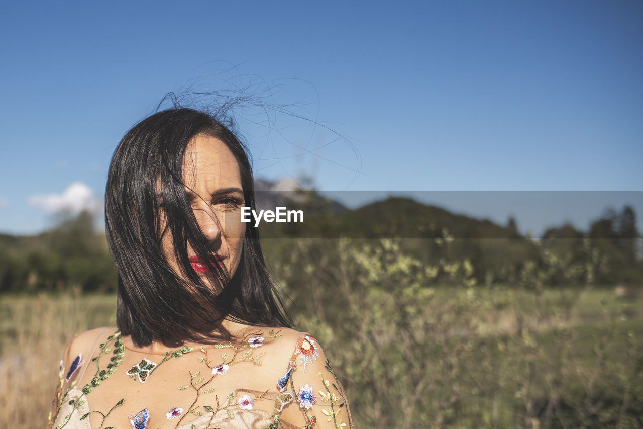 Portrait of woman standing on land against sky