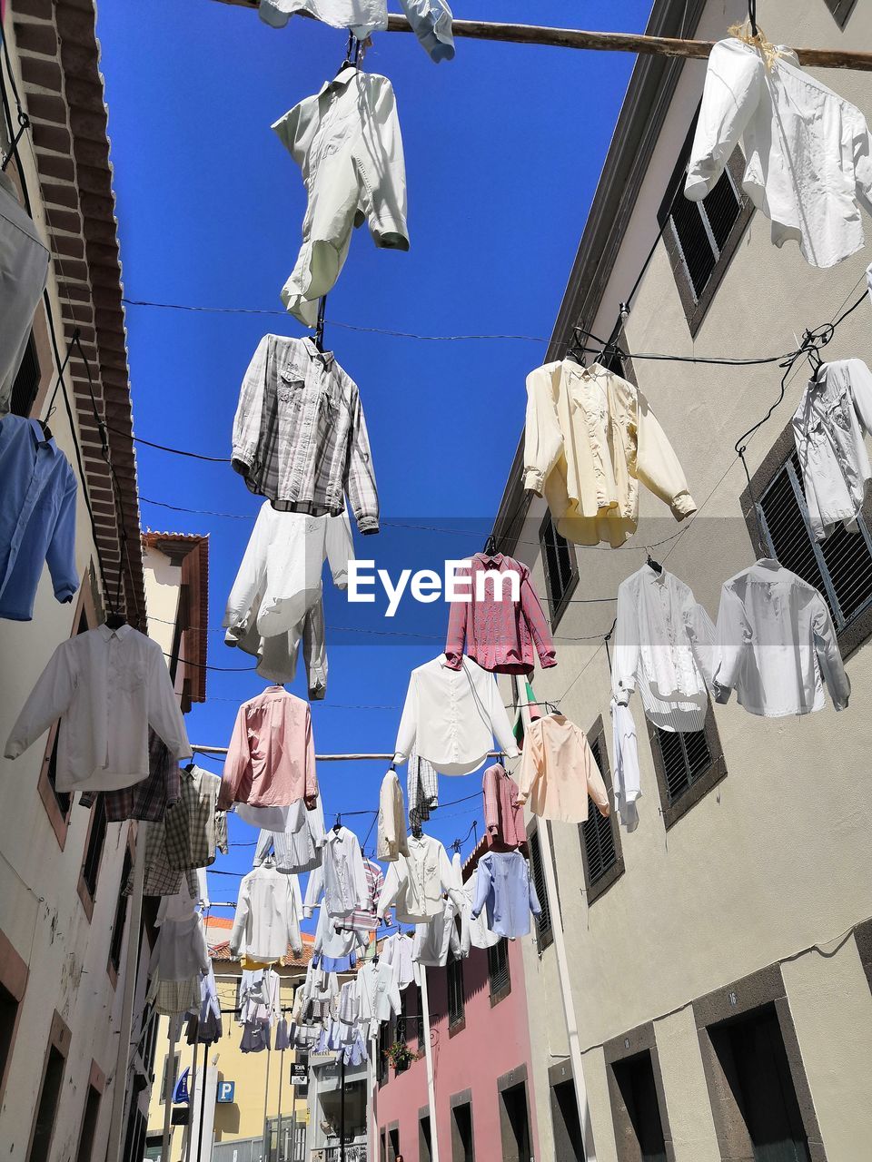 LOW ANGLE VIEW OF CLOTHES DRYING ON BUILDINGS