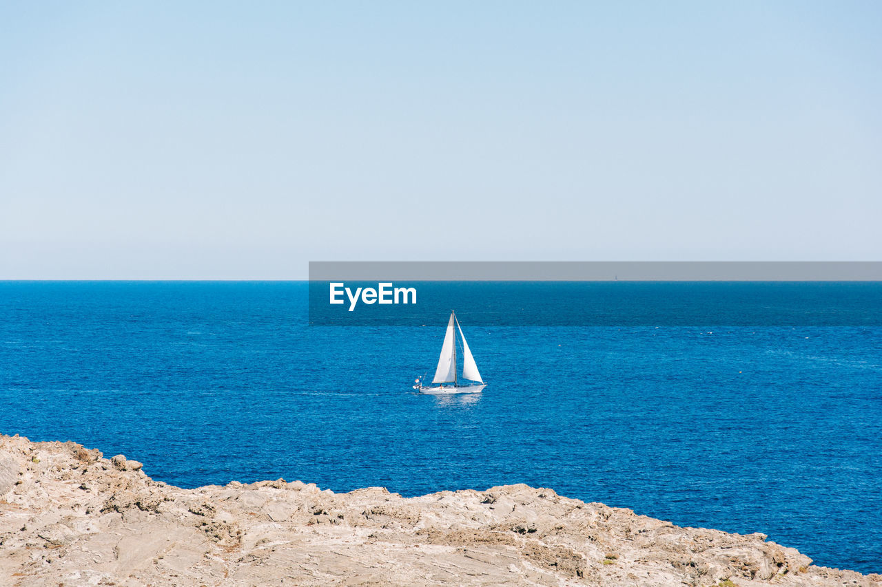 Sailboat sailing on sea against sky