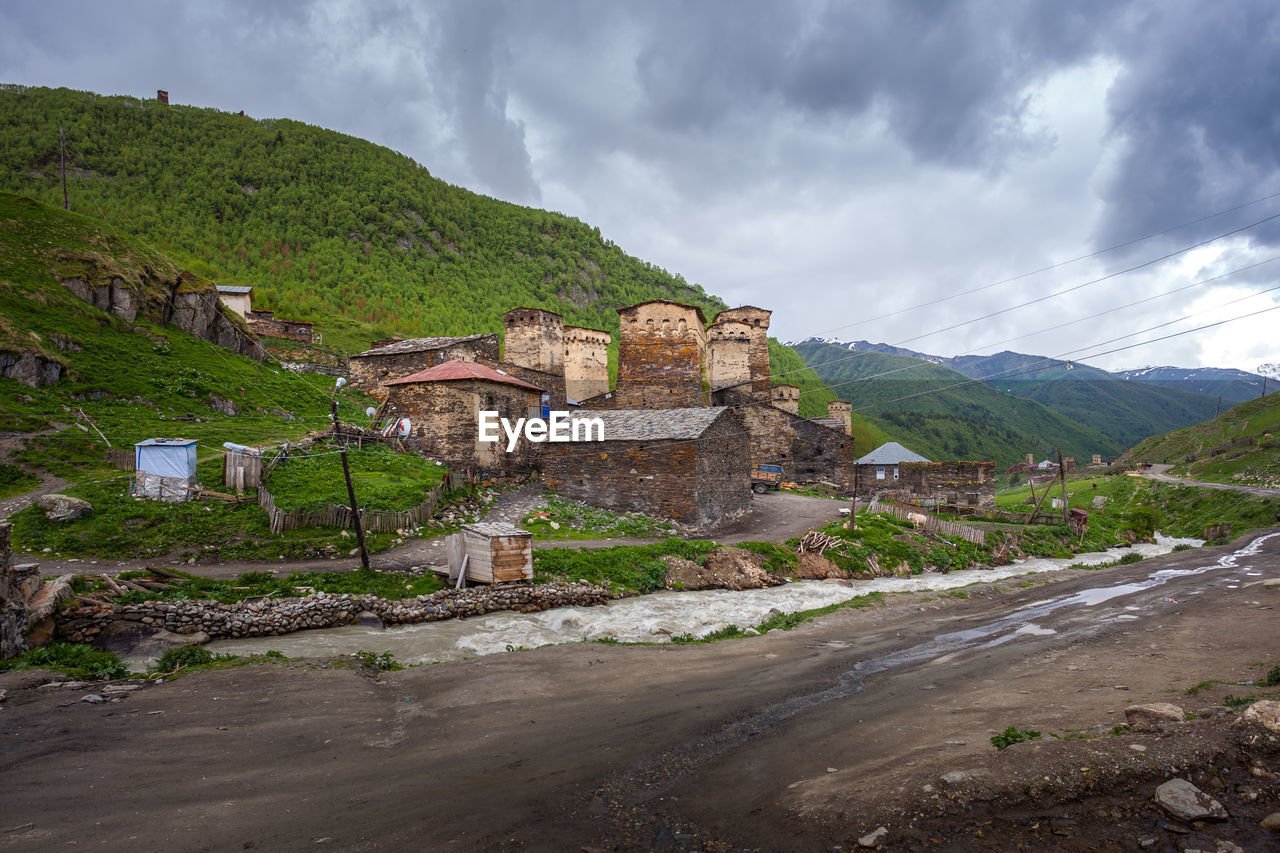 BUILDINGS AGAINST SKY WITH MOUNTAIN IN BACKGROUND