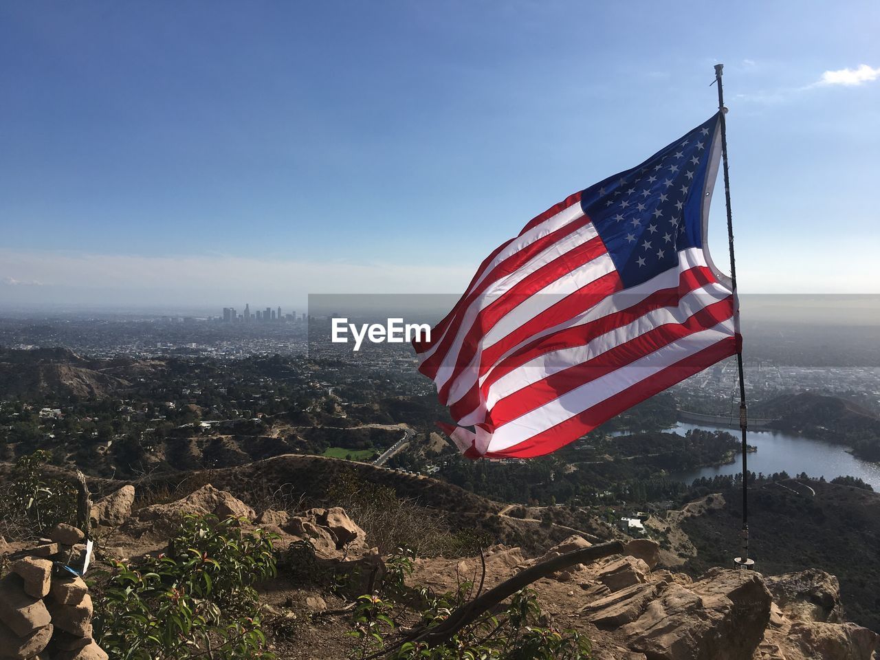 American flag on landscape against sky