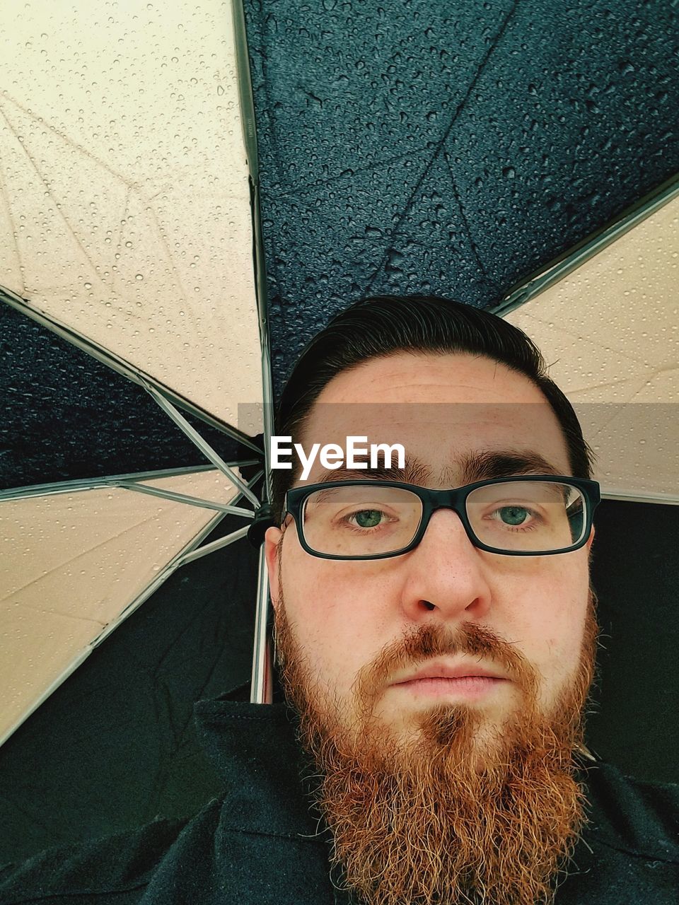 Portrait of bearded man under umbrella