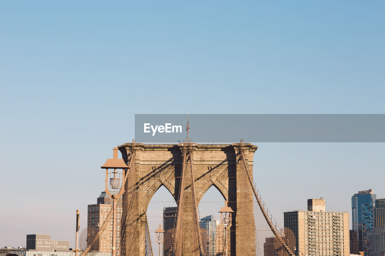 Low angle view of brooklyn bridge against clear sky in city