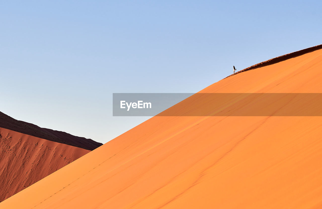 LOW ANGLE VIEW OF TENT IN DESERT AGAINST CLEAR SKY