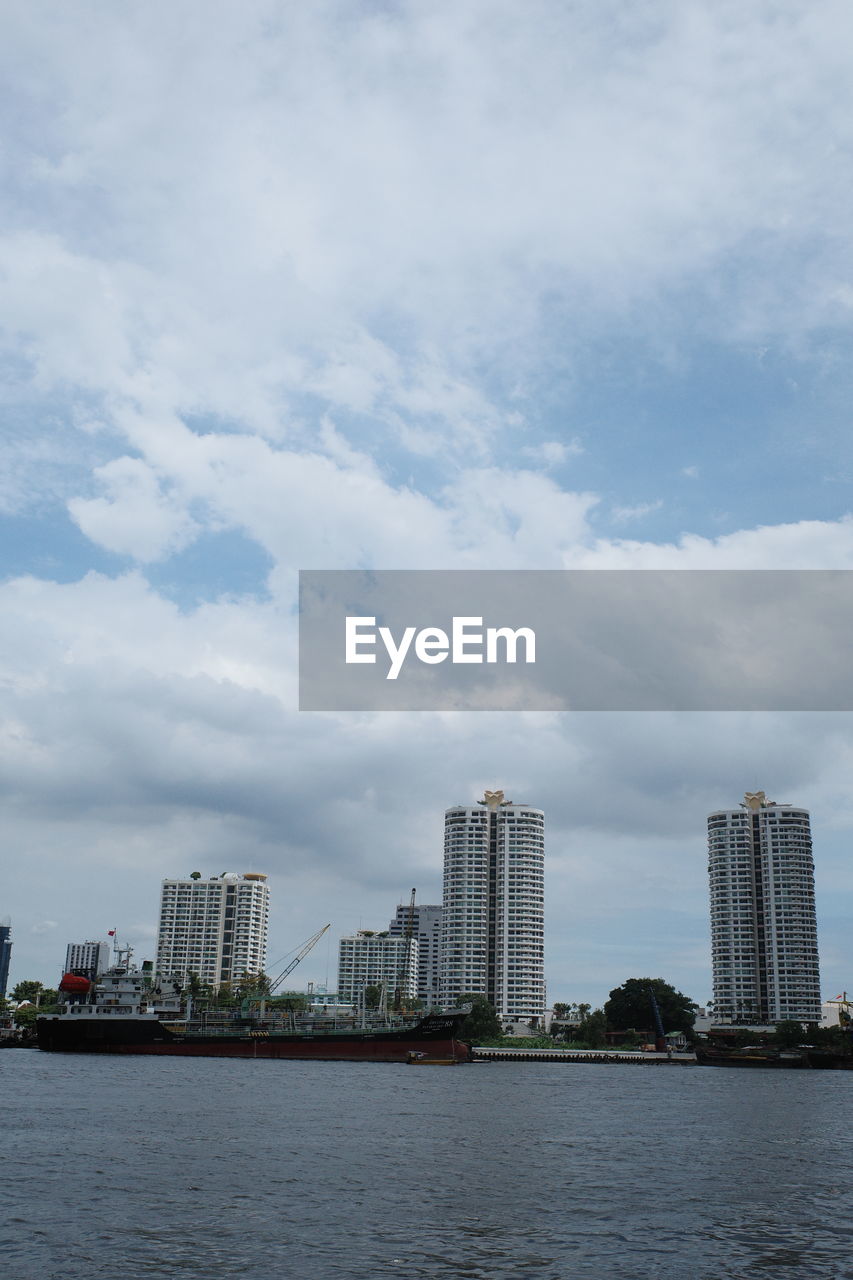 BUILDINGS BY SEA AGAINST SKY IN CITY