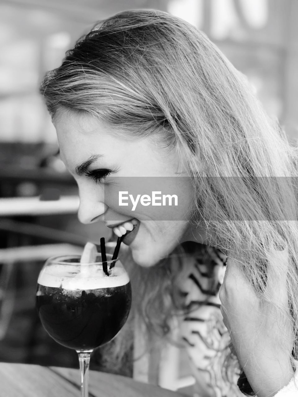 Close-up of woman having drink at table in restaurant