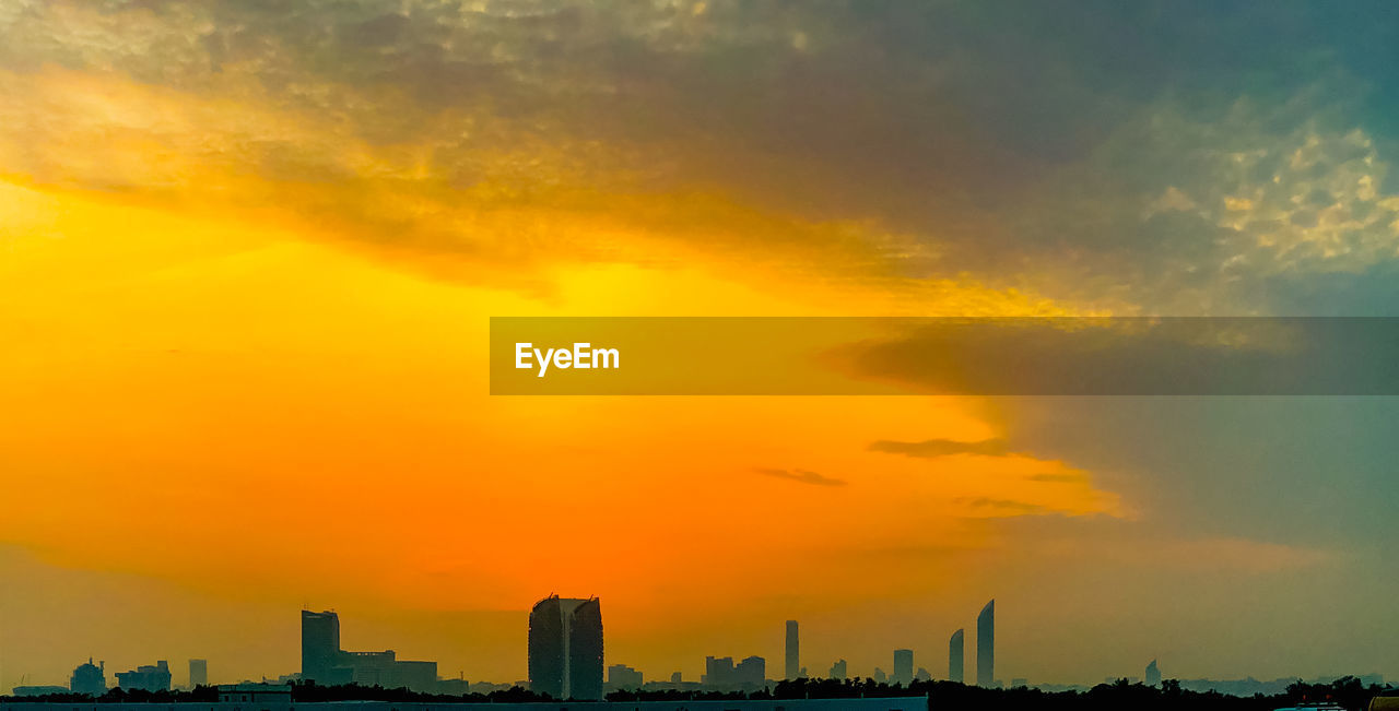 SILHOUETTE BUILDINGS AGAINST ORANGE SKY