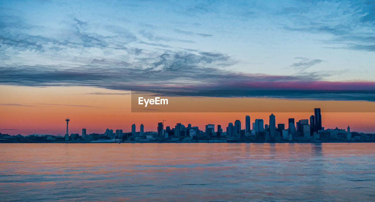 The sun sets creating an eerie glow over the seattle skyline.