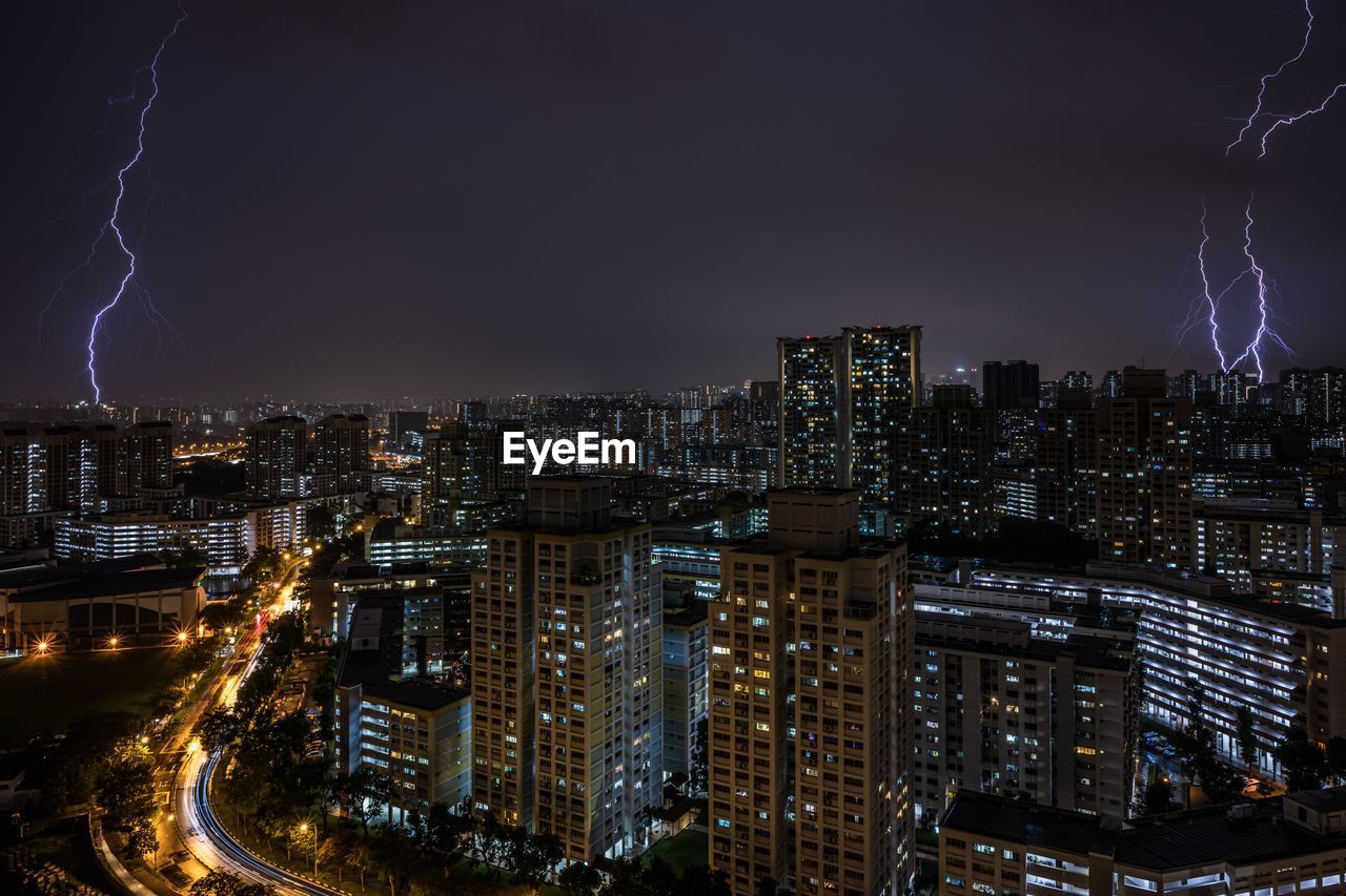 Illuminated cityscape against sky at night