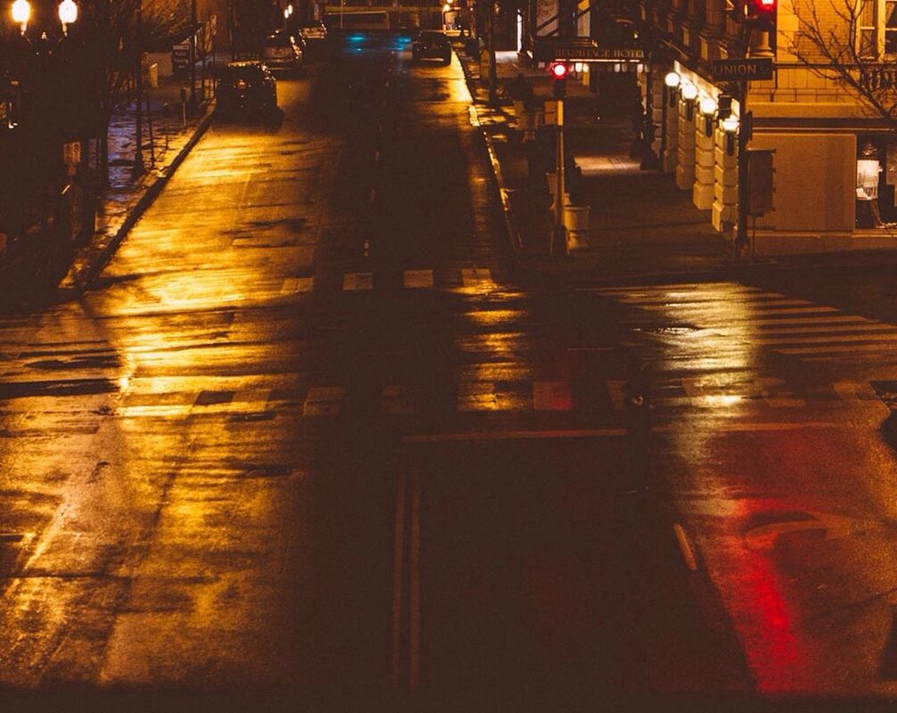 VIEW OF ILLUMINATED ROAD AT NIGHT