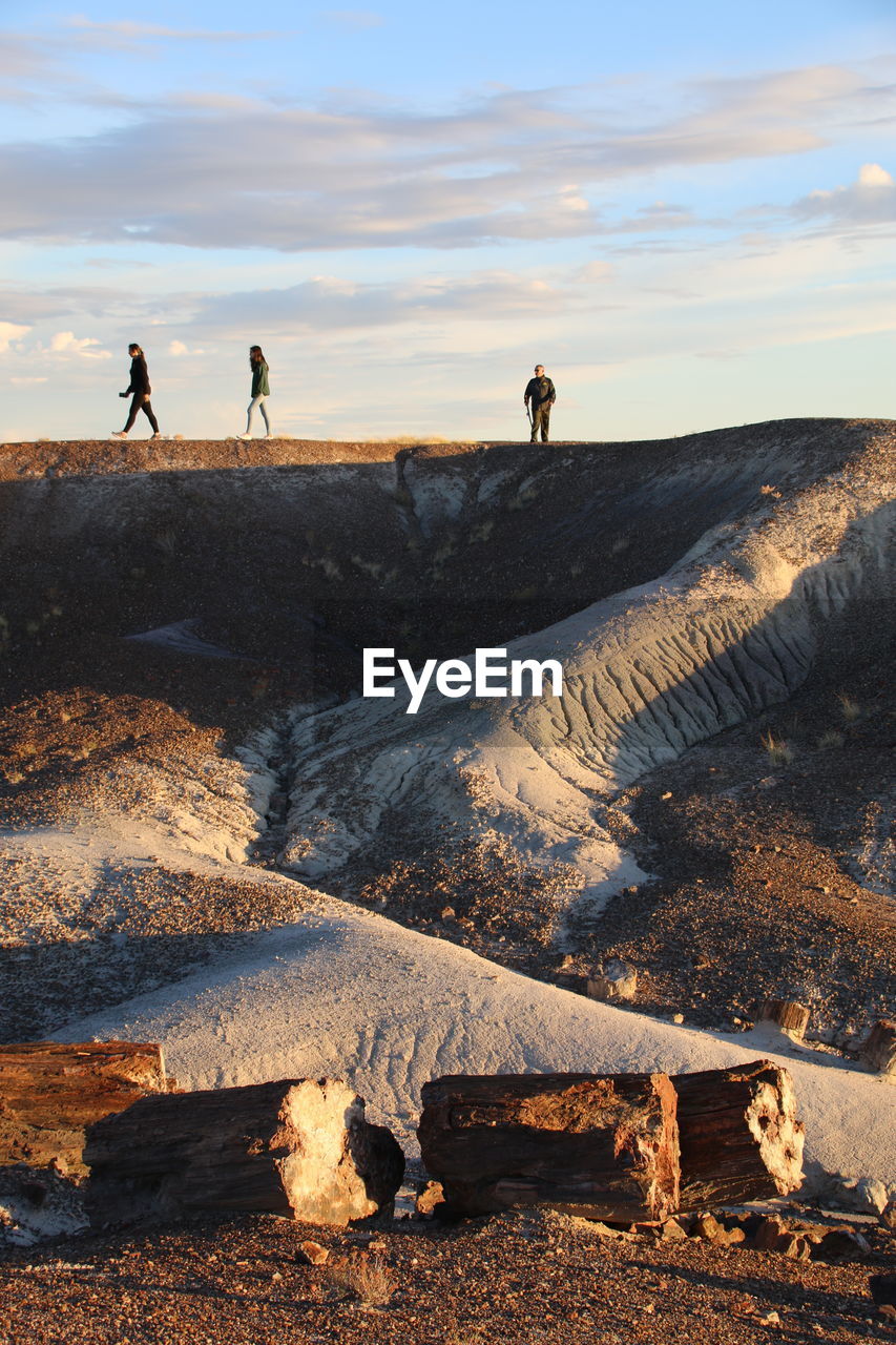 People walking on land against sky