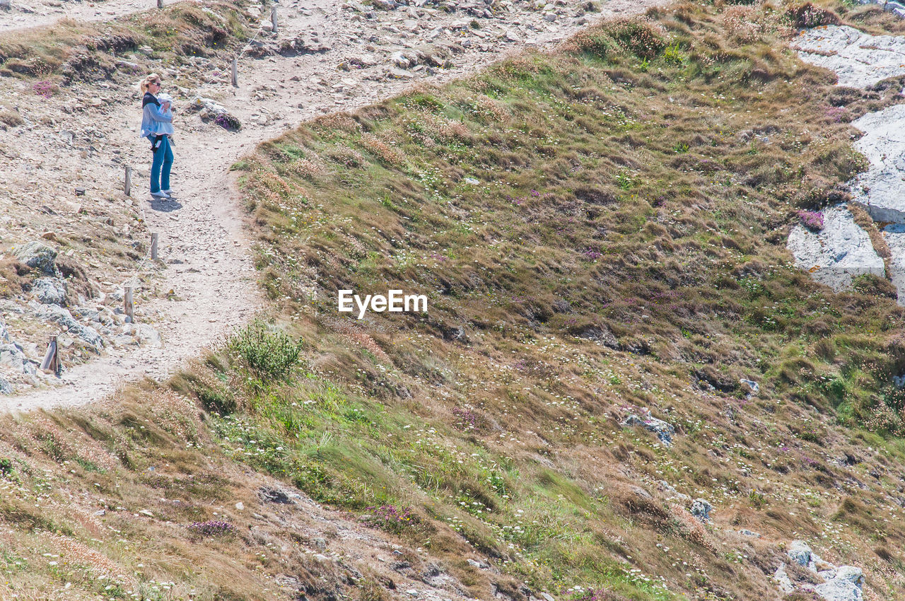 FULL LENGTH REAR VIEW OF MAN WALKING ON LAND