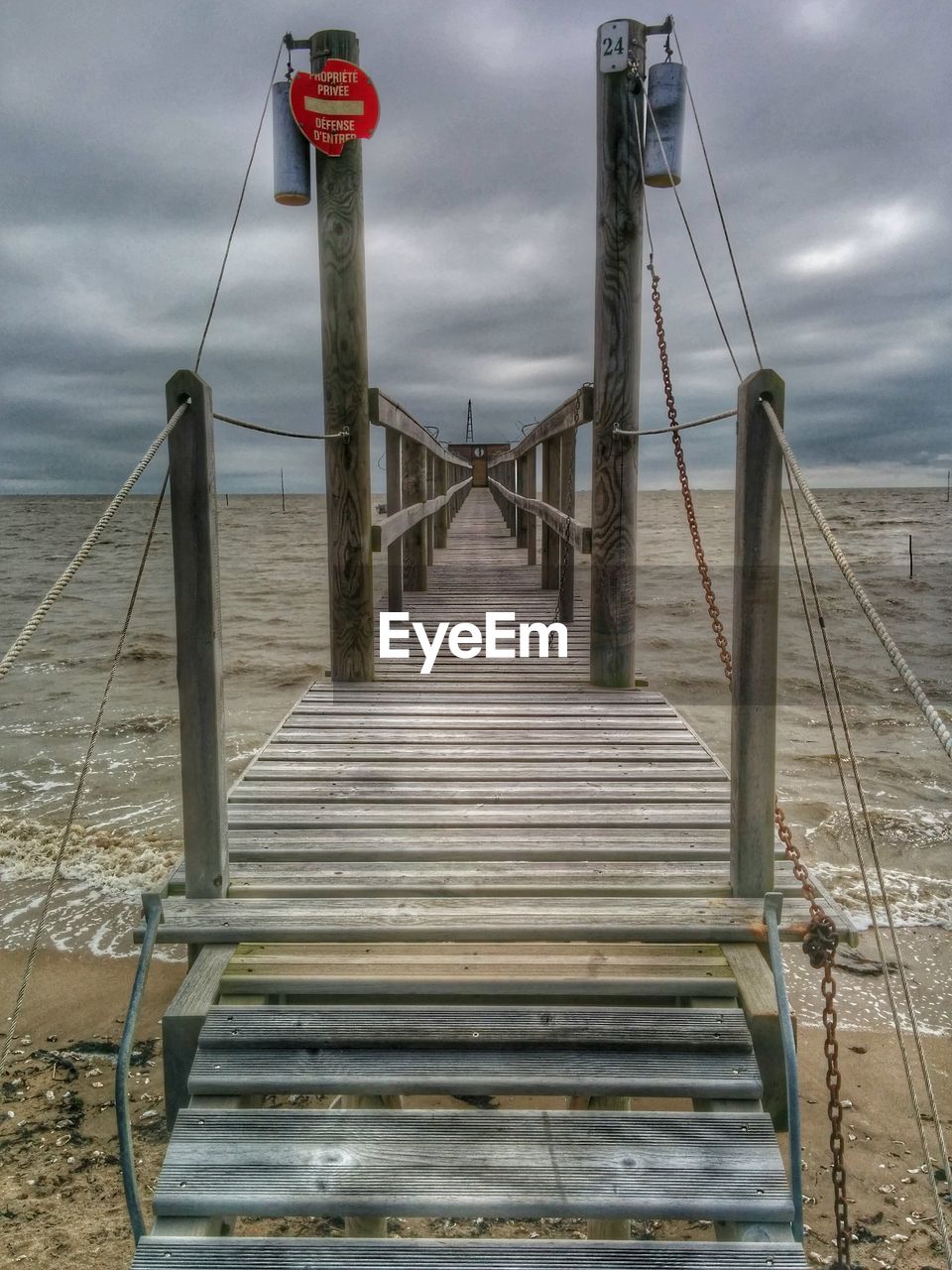 Empty narrow jetty along calm sea