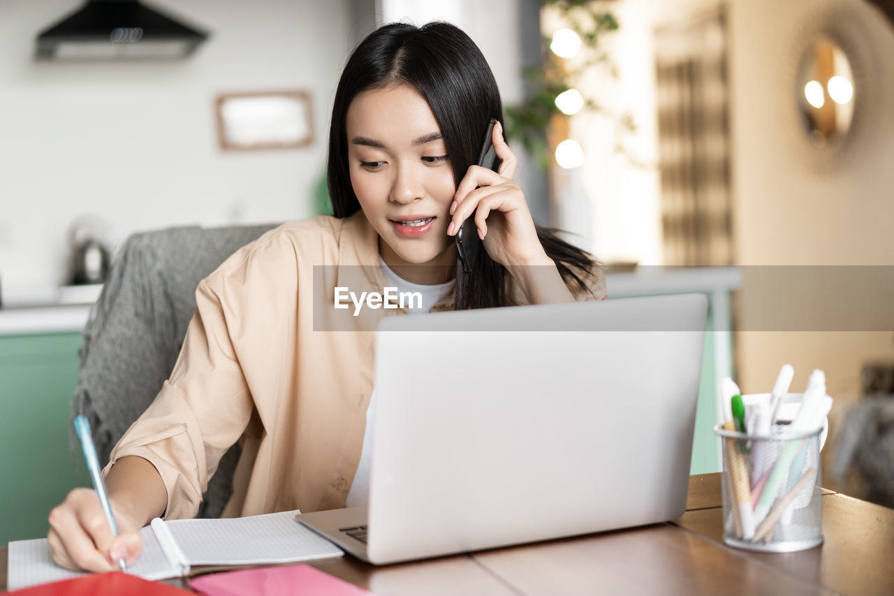 portrait of young woman using laptop at office