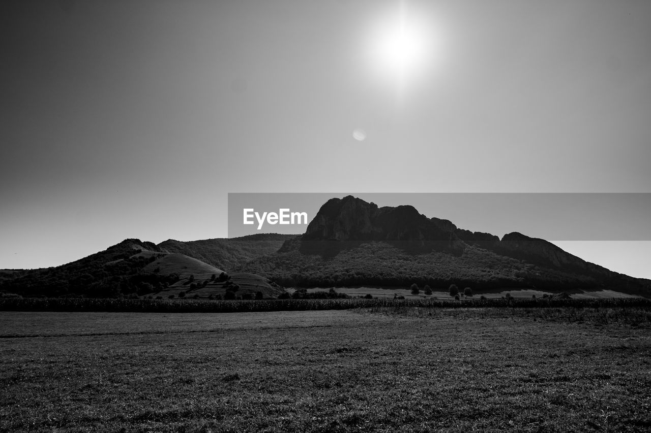 Scenic view of landscape and mountains against clear sky