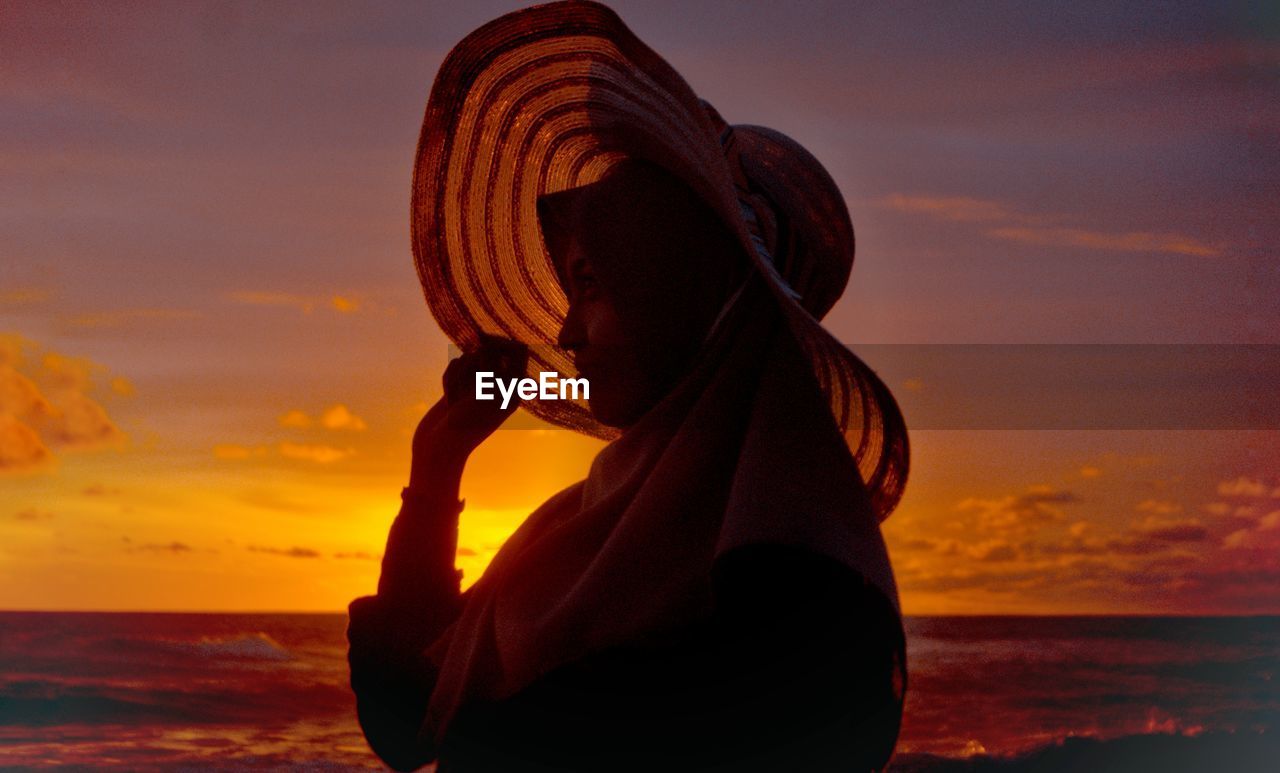 Woman looking at sea during sunset