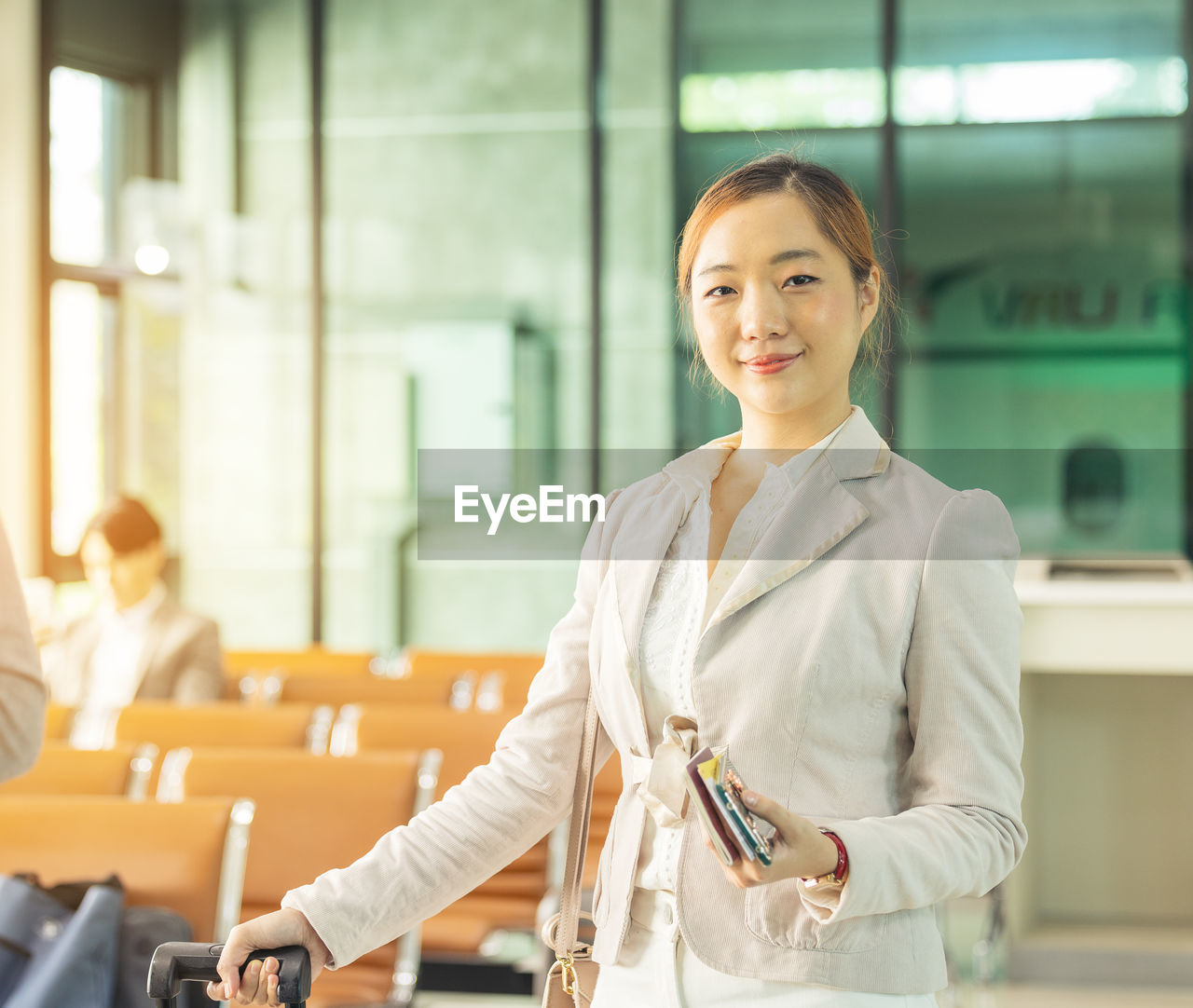 At the airport check-in counter, a passenger hands over his documents to the manager via a counter