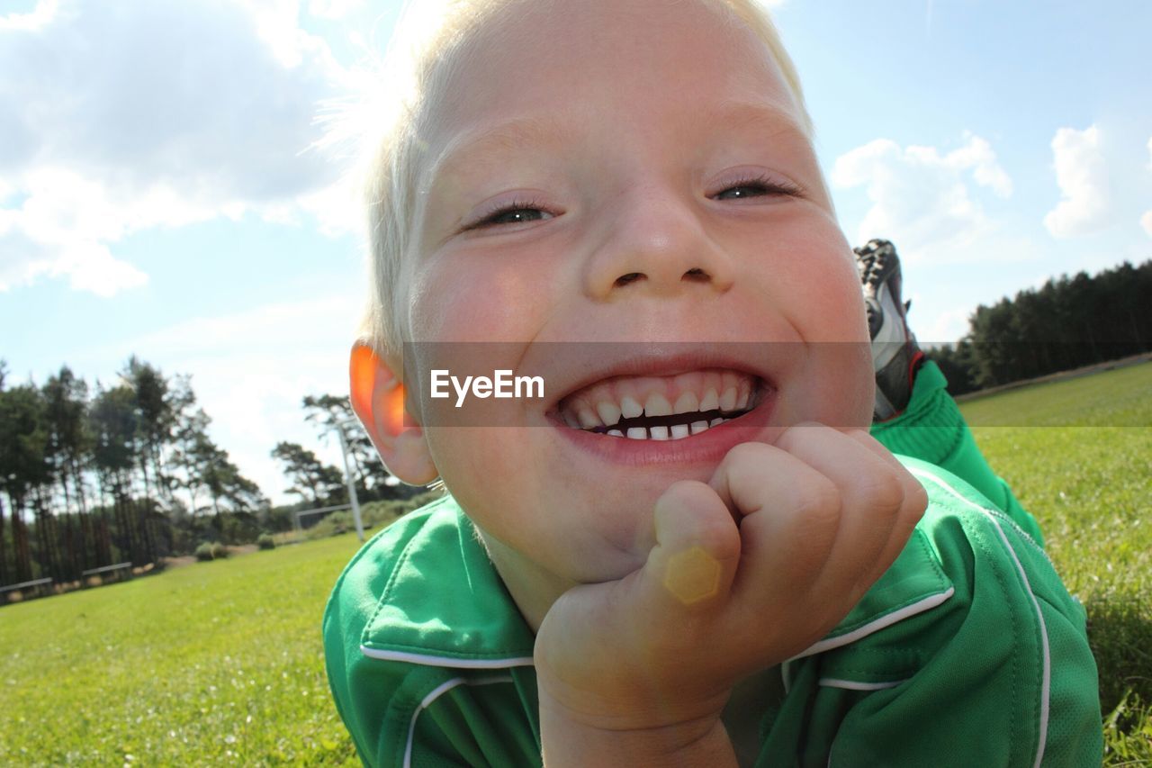 Close-up portrait of smiling boy on field