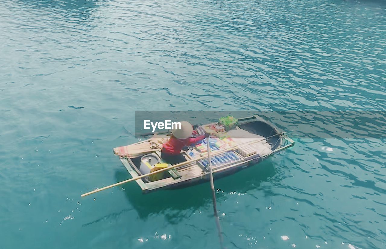 HIGH ANGLE VIEW OF PEOPLE ON BOAT AT SHORE